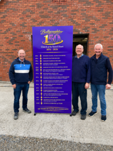 Shane Eivers, Paddy Kenny and Declan Roche pictured with the framed Ballyoughter church timeline. The frame was made by Paddy Kenny