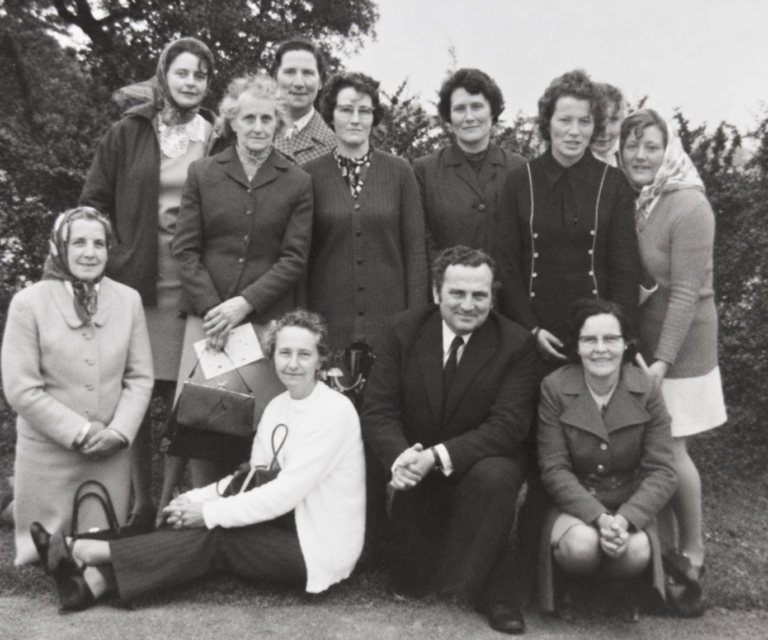 Mary ("Molly") Carter (kneeling on extreme left) with members of Ballyoughter ICA and bus driver on an outing, c. 1973.